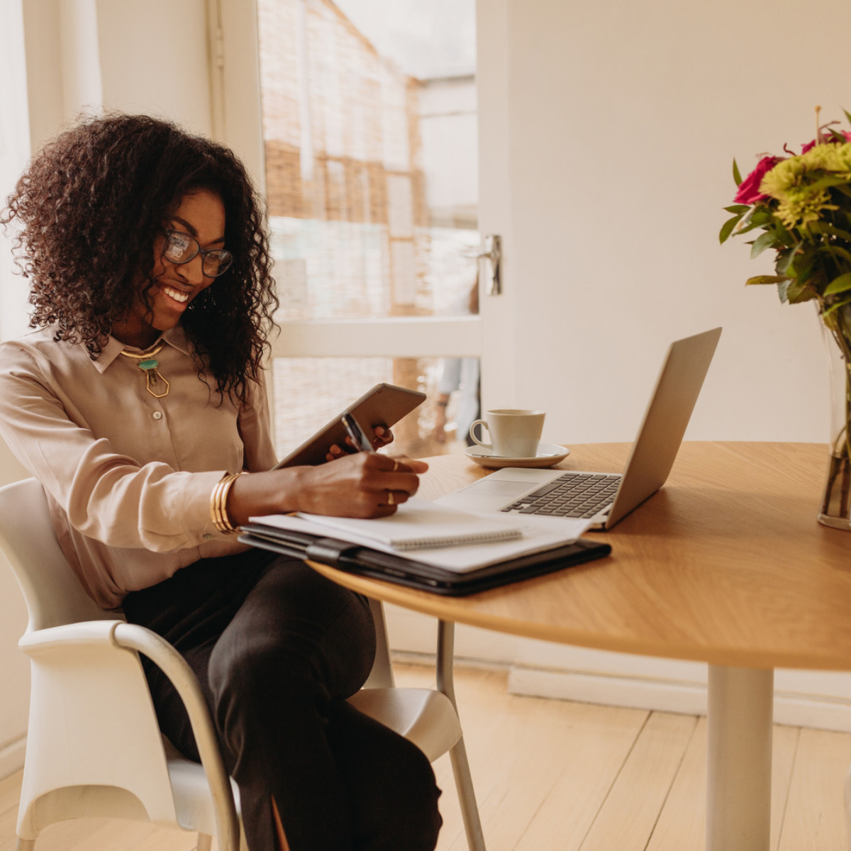 Business professional making notes in front of laptop